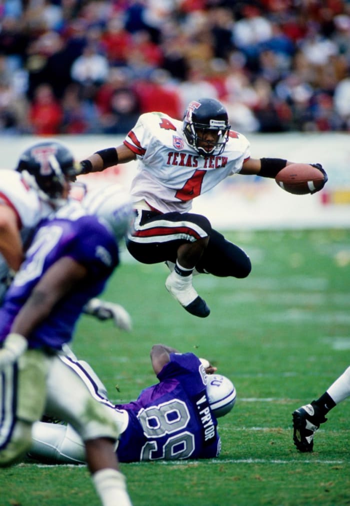 Texas Tech Red Raiders running back Byron Hanspard (4) hurdles Texas Christian Horned Frogs linebacker Vincent Pryor (89) at Amon G. Carter Stadium.
